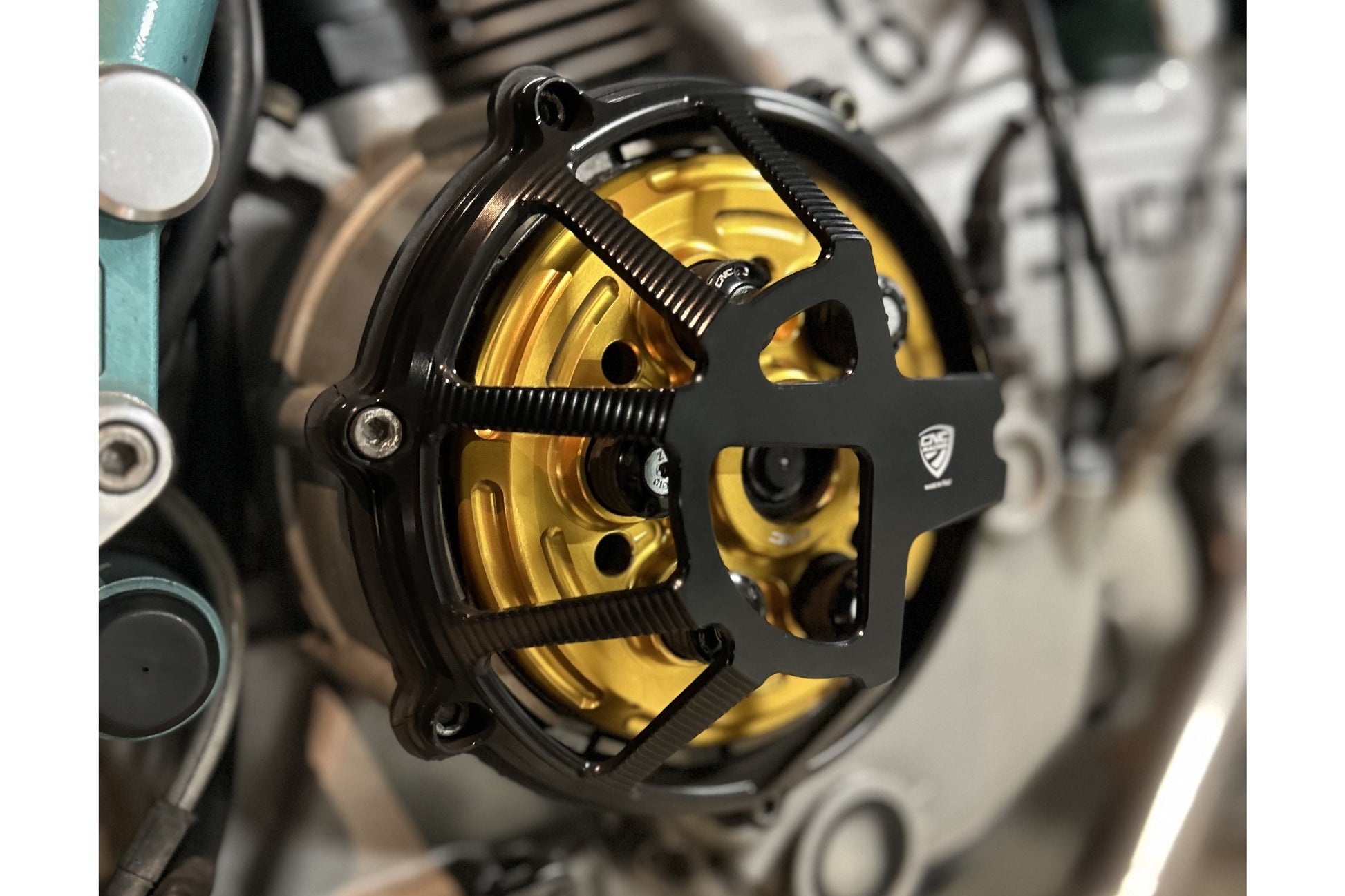 Koppelingsdeksel Traffic Ducati Hypermotard 1100 EVO (2010-2012) vooraanzicht in zwart met gouden drukplaat en zwarte veren plus schotels