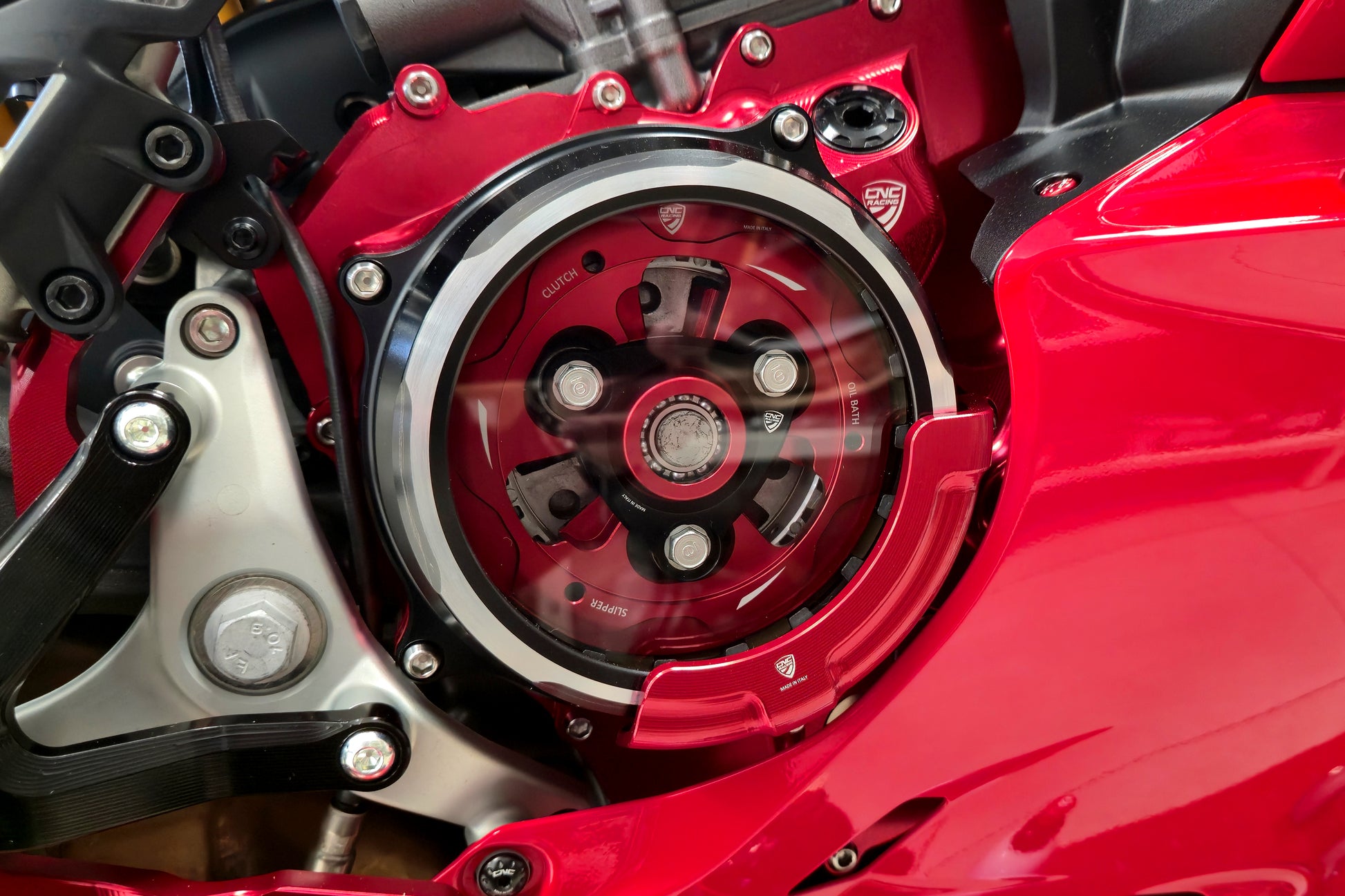 Rode CNC Racing CAP03R beschermer gemonteerd op CA511RB transparant koppelingsdeksel – Ducati 890cc V2 in rood, montagevoorbeeld met zichtbare CNC Racing componenten.