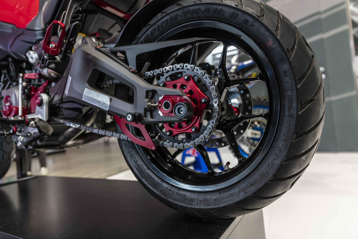 Zijaanzicht van de CNC Racing bovenste kettingbeschermer in mat carbon op een Ducati Multistrada V2, gemonteerd boven de ketting.